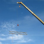 A crane lifts a steel beam