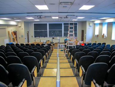 The Ernie Pyle Hall auditorium, with rows of seats and three large chalkboards at the front of the room