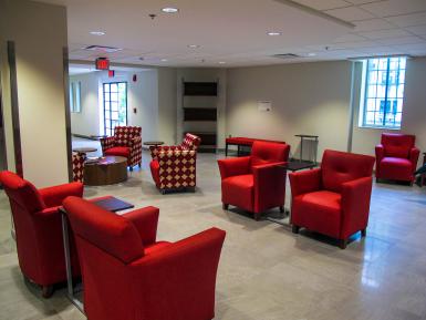 A lounge area, with a mixture of solid red and patterned seating.