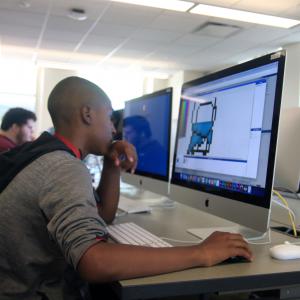 A student works on a computer in the multimedia lab