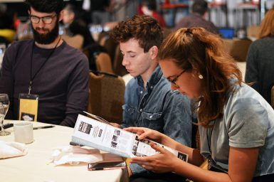 Brewer (left) and Bryniarski look through the conference program.