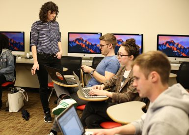 Jonah Chester, a senior majoring in journalism, asks adjunct instructor Allison Quantz questions about a class project in MSCH-J460: Radio Innovation.