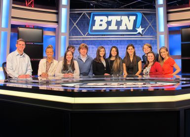 Students pose behind CBS2 anchor desk.