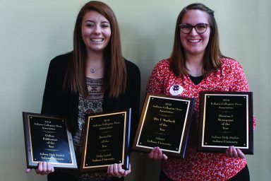 Carley Lanich and Molly Cunningham hold awards won by the IDS and Arbutus.