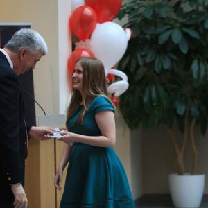 Dean Jim Shanahan recognizes a smiling Audrey Deiser with a handshake and a small gift.