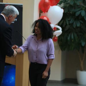 Dean Jim Shanahan recognizes Elisabeth Dunn with a handshake and a small gift.