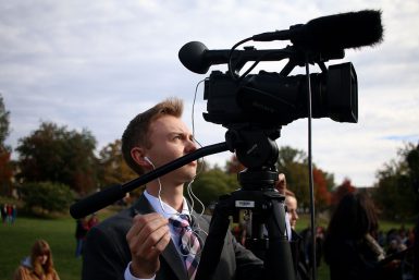 Andrew Lamparski positions a camera in Dunn Meadow