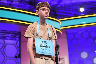 A teenage boy with a sign around his neck that says: "128; Daniel; Indiana University; Bloomington, Indiana"