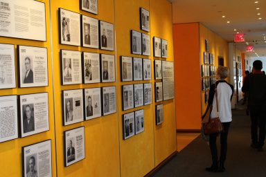 A student walks through a gallery honoring New York Times Pulitzer Prize winners.