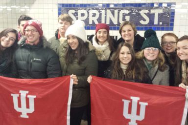 Students pose with IU flags in the New York City subway.