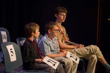 Three children sitting next to each other in chairs