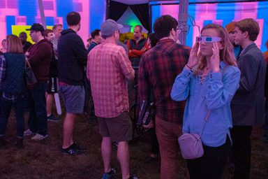 Students immerse themselves in the 12-foot-tall octagonal array of viewing screens and speaker systems at Lotus World Music and Arts Festival this weekend.
