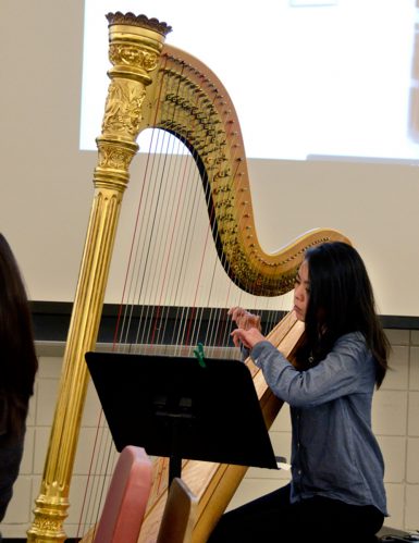 Harpist Peggy Huong played music composed by student Ray D. Kim as the short film, <i>The Investigation,</i> showed on a screen behind her. (Maggie Richards, senior | The Media School)