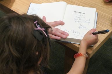 Juniper signing a book