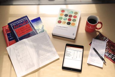 Books, an ipad and a coffee cup on a table
