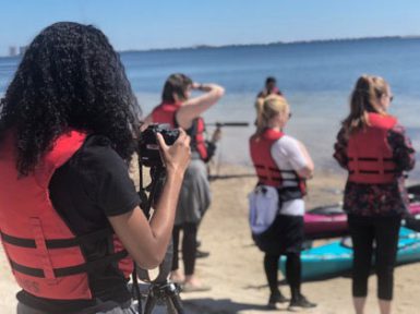 Students prepare to film a kayaking video during the 2018 Gulf Islands National Seashore alternative spring break trip.