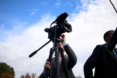 Andrew Lamparski positions a camera in Dunn Meadow