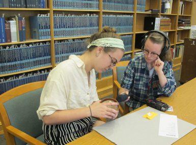 Media School seniors Abigail Gipson and Emily Miles, student producers of the podcasts Through the Gates and The Sample, record an episode of The Sample on puzzles at the Lilly Library.