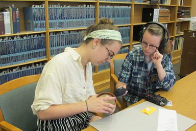 Media School seniors Abigail Gipson and Emily Miles, student producers of the podcasts Through the Gates and The Sample, record an episode of The Sample on puzzles at the Lilly Library.