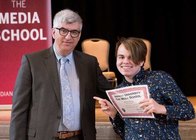Dean James Shanahan presented students with their scholarship certificates. Here, Jackson Evans accepted the Freedom of the Press scholarship. (Ann Schertz | The Media School)
