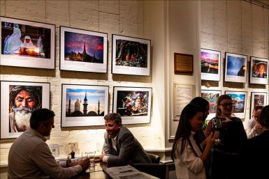 People mingle while viewing Raymer's photographs