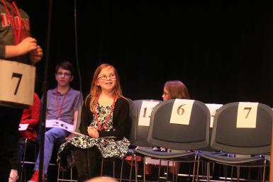 Brown County Intermediate School fifth grader Alayna Jacobus sitting in a chair smiling, surrounded by many emty chairs.