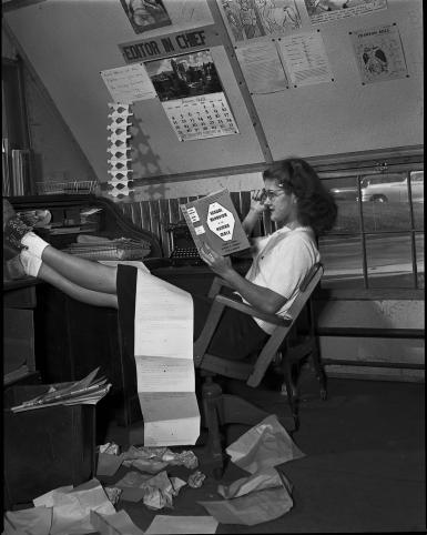 Marjorie (Smith) Blewett reads Alfred Kinsey's "Sexual Behavior in the Human Male" at the Indiana Daily Student editor's desk.