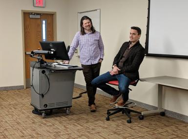 Galen Clavio and Rhett Lewis next to a podium