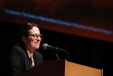 Maggie Haberman standing at a podium, smiling.