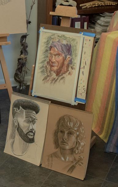 Three sketches of people arragned on an easel