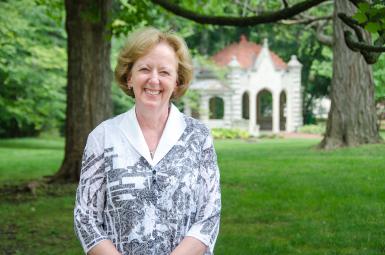 Nancy Comiskey standing in front of the Well House