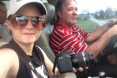 M.S. student Layn Pieratt rides in a car with her father, Marty Pieratt. Layn is holding a camera.
