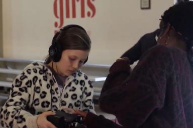 Two girls opearing a video camera together