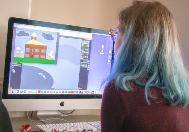 Willow Borden looks at a computer screen, which displays a drawing of a house.