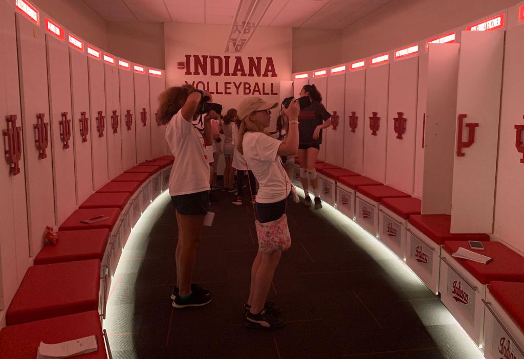 Girls take photos in the IU volleyball locker room.