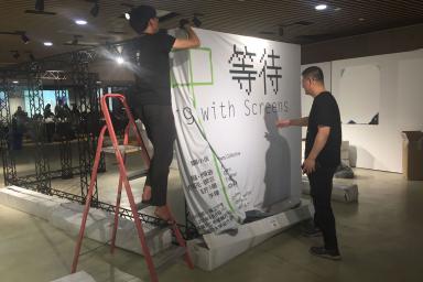 Shaw Xu Zhifeng and professor Zhou Hongtao set up the exhibition frame.