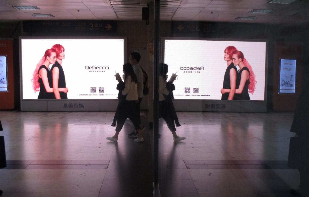 Split-screen image of a woman walking past a digital advertisement