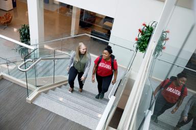 Two women walk up the stairs in the commons