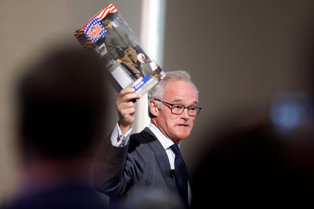 Scott Pelley holds up an Ernie Pyle G.I. Joe doll