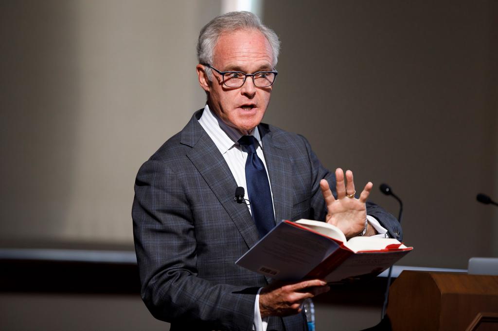 Scott Pelley reads from a book.