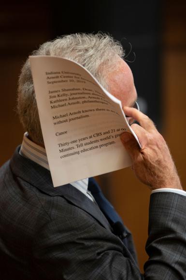 Scott Pelley holds up a script.