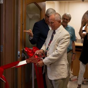 Michael I. Arnolt, BS'67, the donor behind the Michael I. Arnolt Center for Investigative Journalism, cuts the ceremonial ribbon to open the center.