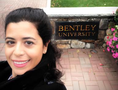 A selfie of Julide Etem in front of a Bentley University sign