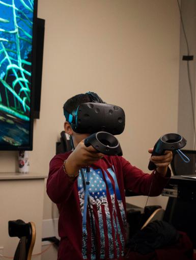 A boy wearing a virtual reality headset and using controllers