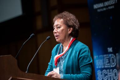 Edna Einsiedel speaking at a podium