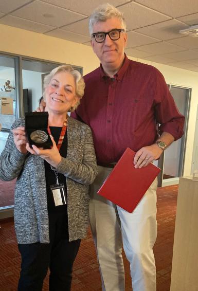 Dean James Shanahan presents undergraduate administrative services coordinator Marilyn Behrman with IU's Bicentennial medal.