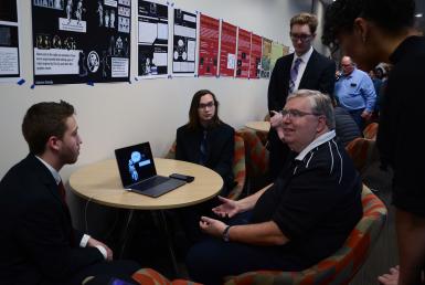 Paul Stephanouk, senior creative director at King, and CJ Ajawara, Blair Wheatley, Carson Hurwitz and Angel Aynes sit at a table and look at a computer.