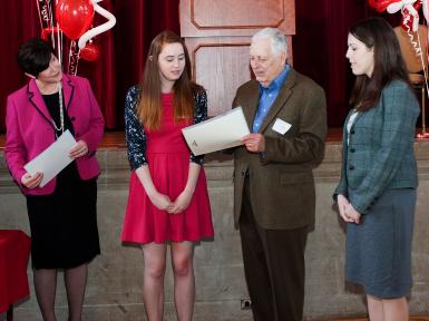 Four people stand at an awards ceremony.