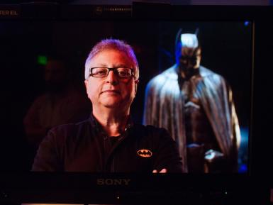 Michael Uslan standing in front of a Batman costume
