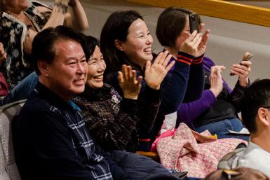 Yena's family sits and claps.